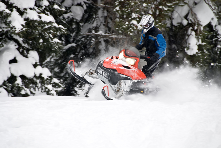 A skilled snowmobiler riding in extreme powder.