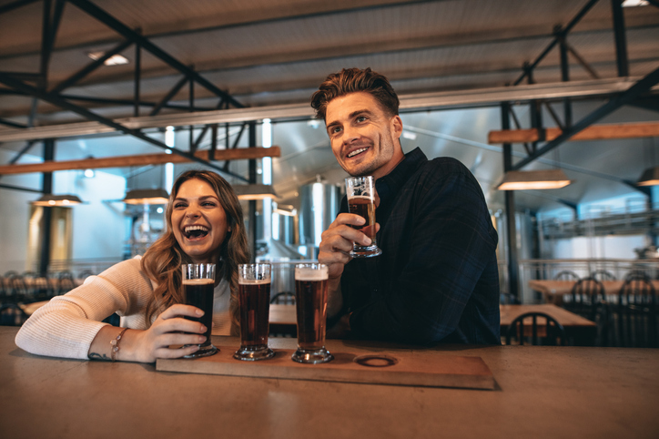 Couple at the bar with different varieties of craft beers