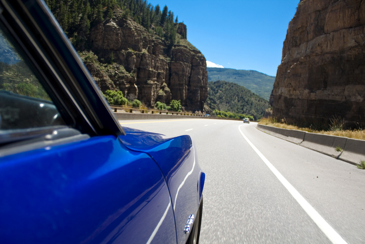 the front passenger's side of a classic car on the road in the Glenwood Canyon in Colorado